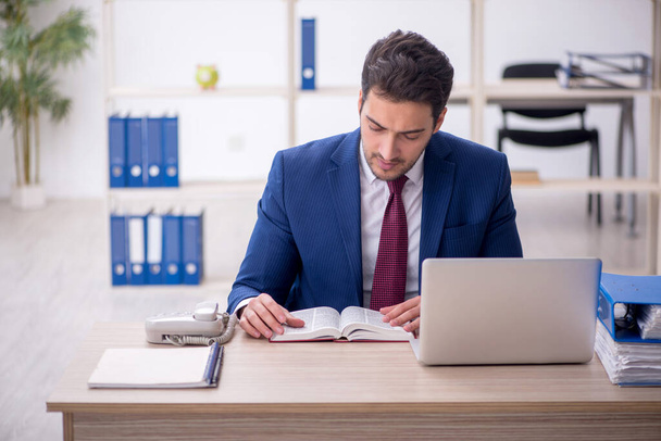 Young businessman employee reading book in the office - Φωτογραφία, εικόνα