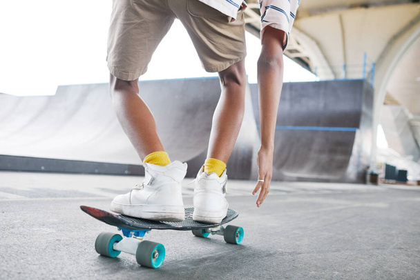 Close up de jovem adolescente montando skate no parque de skate ao ar livre, espaço de cópia - Foto, Imagem