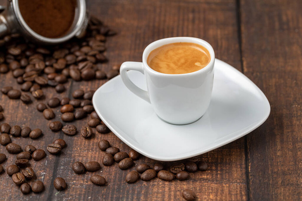 木製テーブルの上にコーヒー豆で飾られた新鮮なエスプレッソコーヒー - 写真・画像
