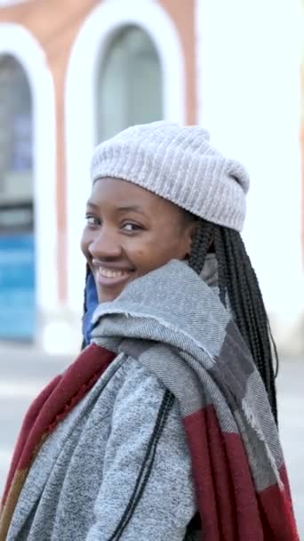 Ritratto di giovane donna africana con eterocromia che guarda la macchina fotografica e sorride in inverno. - Filmati, video