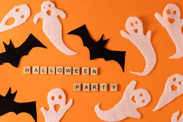 White ghosts and bat craft for Halloween party. Wrapping paper ghost on orange background top view. Cartoon creepy Whisper. DIY hand made. Set boo characters. Word wooden letter phrase. - Foto, afbeelding