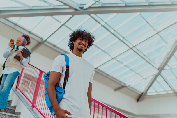 Afrikai amerikai diák kék hátizsákkal, modern afro frizurával és széles mosollyal, lelkesedést sugároz és képviseli a modern egyetem élénk szellemét, megtestesítő ambíciót - Fotó, kép