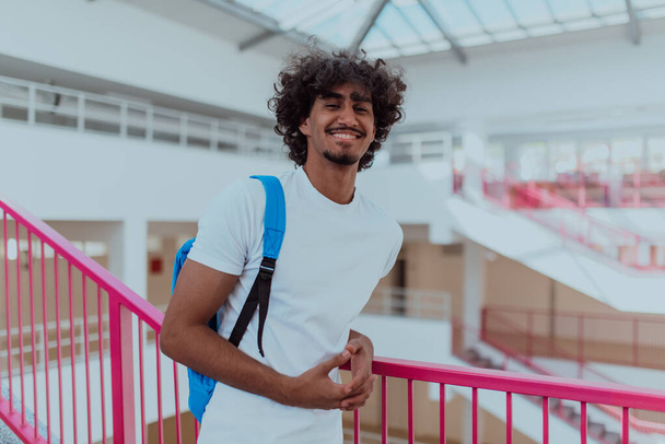 Studente afroamericano con uno zaino blu, con una moderna acconciatura Afro e un ampio sorriso, irradia entusiasmo e rappresenta lo spirito vibrante di un'università moderna, incarnando l'ambizione - Foto, immagini