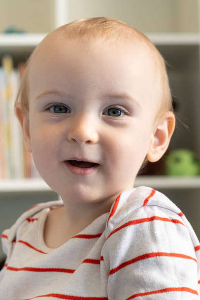 Portrait d'un bébé d'un an, un garçon blond dans une chambre d'enfant - Photo, image