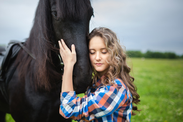 Giovane bella ragazza con cavallo frisone
 - Foto, immagini