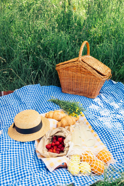 piknik s croissanty, jahodami a limonádou na modré kostkované přikrývce - Fotografie, Obrázek