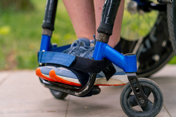 Osallisuus Kaupunkipuistossa pyörätuolilla ajavan vammaisen miehen jalat lähikuvassa - Valokuva, kuva