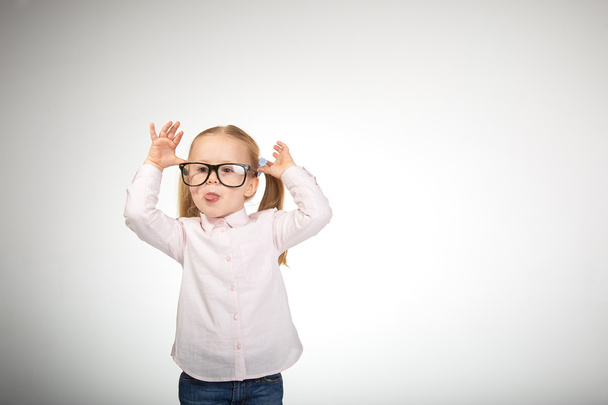 Schattig klein meisje met een bril op een witte achtergrond - Foto, afbeelding