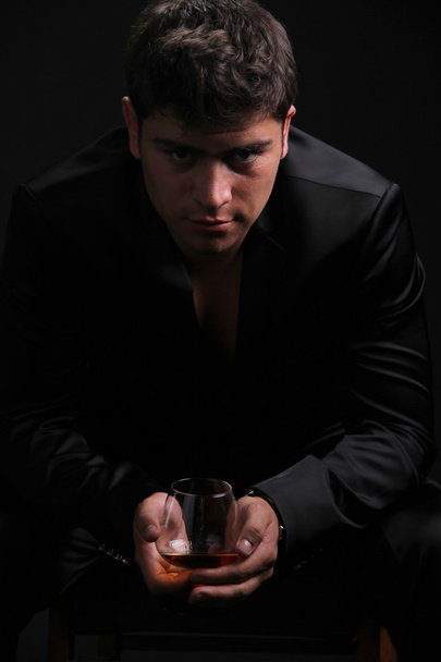 Man with glass of cognac on dark background - Фото, зображення