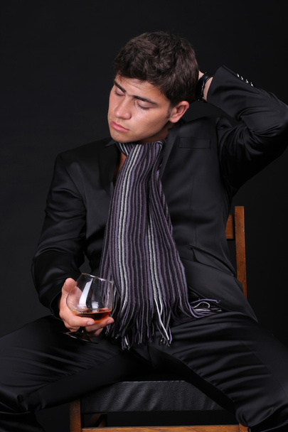 Man with glass of cognac on dark background - Foto, imagen