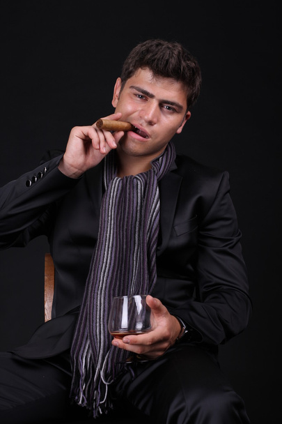 Handsome man holding cigar with smoke - Foto, immagini