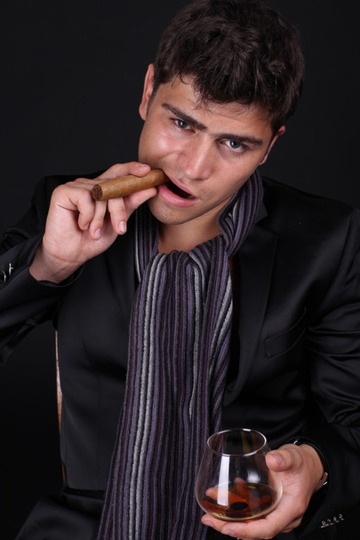 Handsome man holding cigar with smoke - Foto, Bild