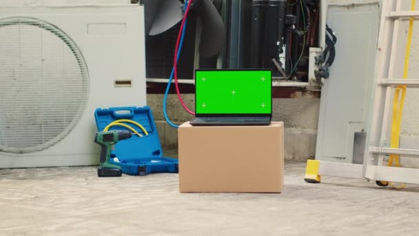 Green screen laptop in front of out of service outside air conditioner. Mock up chroma key gadget display next to damaged external HVAC system in need of expert maintenance - Video