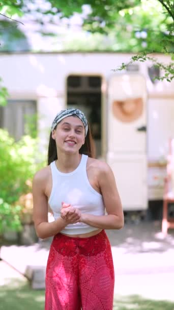 The beautiful hippie girl is talking in front of the trailer. High quality 4k footage - Filmagem, Vídeo