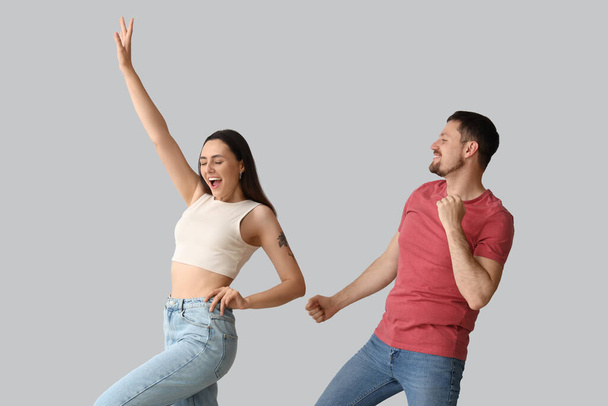 Happy young couple dancing on light background - Foto, imagen