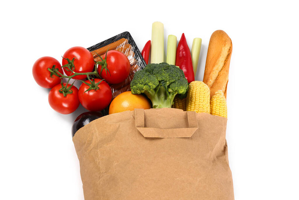 Papiertüte mit verschiedenen Produkten auf weißem Hintergrund. Lebensmitteleinkaufskonzept - Foto, Bild