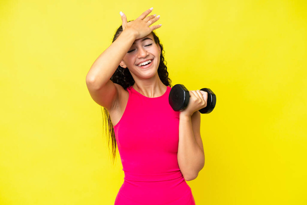 Young sport woman making weightlifting isolated on yellow background has realized something and intending the solution - Foto, Imagem