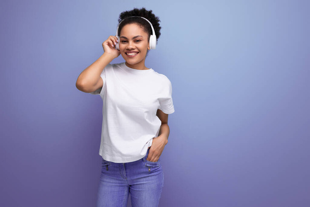 junge brünette lateinamerikanische Frau im weißen T-Shirt hört ihre Lieblingsmusik über Bluetooth-Kopfhörer. - Foto, Bild