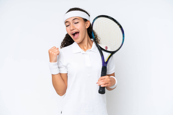 Jeune joueuse de tennis isolée sur fond blanc célébrant une victoire - Photo, image