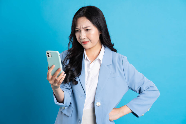 retrato de joven mujer de negocios asiática posando sobre fondo azul - Foto, imagen
