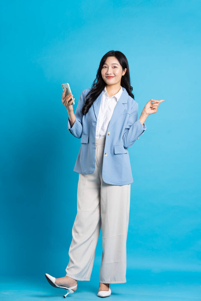 Азиатский портрет молодой предпринимательницы на синем фоне - Фото, изображение