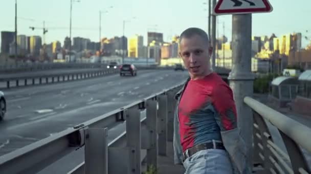 Urban Rhythm, Young Man In mostra Freestyle Dance si muove su un ponte in un paesaggio urbano vibrante. Filmati 4k di alta qualità - Filmati, video