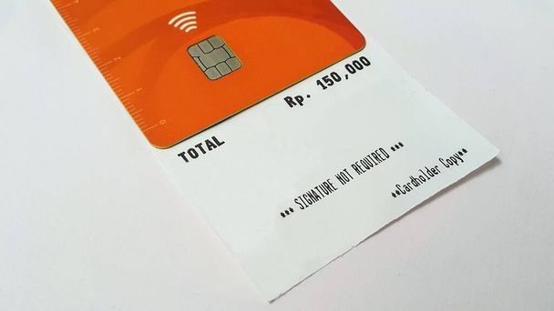 A contactless payment icon symbol on a debit card on top of sales receipts - Photo, image