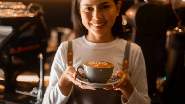 Latte art in barista hand ready to drink in modern coffee shop - Foto, Imagen