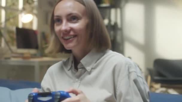 Borst up handheld camera shot van jonge vrolijke vrouw spelen video game met opwinding terwijl het doorbrengen van tijd thuis - Video