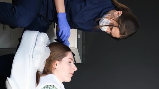 Молодая женщина с проблемами с волосами получает инъекцию в клинике. Руки доктора делают инъекции женщине в кожу головы в салоне красоты. - Кадры, видео
