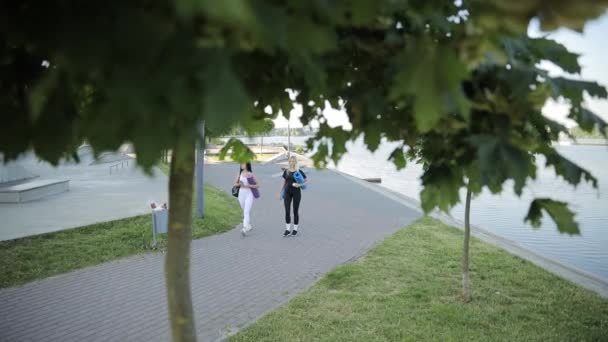 Молодые спортсменки в спортивной одежде ходят на фитнес-тренировки в городской парк. - Кадры, видео