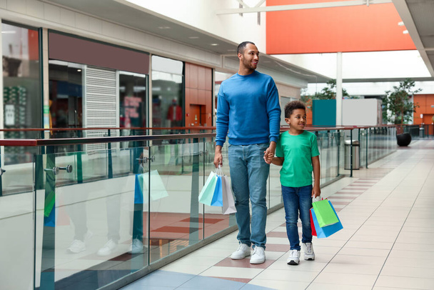 Family shopping. Happy father and son with colorful bags in mall - Foto, Imagem