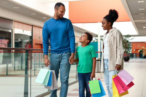 Compras familiares. Pais felizes e filho com sacos coloridos no shopping - Foto, Imagem