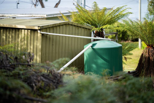 Пластиковый резервуар для воды в лесу автономного дома в Австралии в час ночи - Фото, изображение