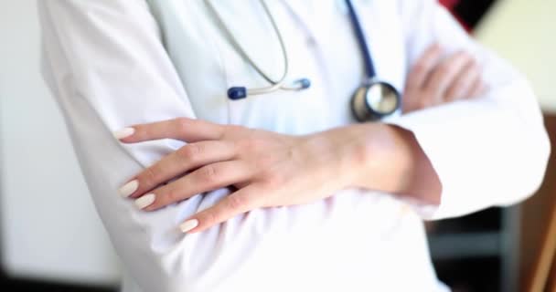 De dokter in een wit uniform kruiste zijn handen, een close-up, slow motion. Medische specialist, beroep - Video