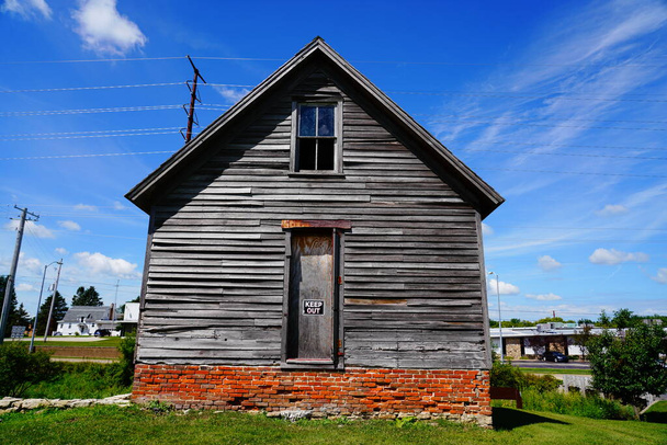 Antigua casa de madera vintage abandonada se sienta en la ladera de Ripon, Wisconsin durante el hermoso clima nublado de julio. - Foto, imagen