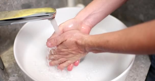 Egy férfi kezet mos a víz nyomása alatt, közelről. Higiéniai eljárás, modern vízvezeték-szerelés - Felvétel, videó