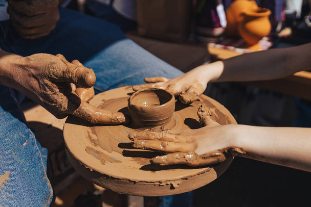 Teaching pottery to children. A master teaches a child pottery. Children's pottery studio - Photo, Image