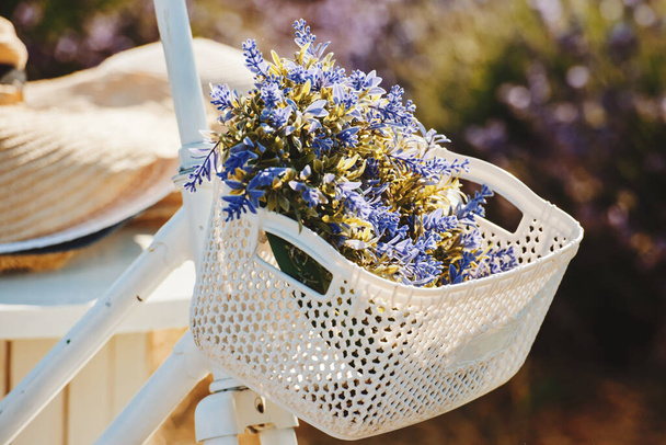 Pyörä kori kukkia vastaan laventeli kenttään. Pehmeä painopiste. - Valokuva, kuva
