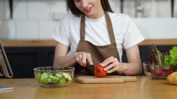 Mujer picando verduras preparándose para cocinar con sonrisa saludable en la cocina en casa. Disfrute del proceso de cocción. - Metraje, vídeo
