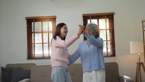 Mutter tanzt mit Tochter glücklich zu Hause. - Filmmaterial, Video