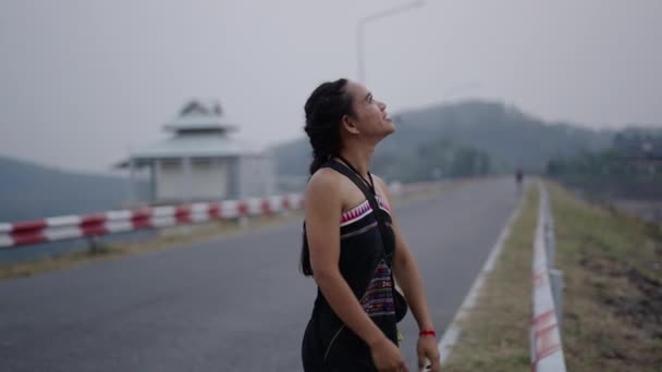 Νεαρή γυναίκα περπατά κατά μήκος του δρόμου και ανοίγει τα χέρια της - Wanderer - Πλάνα, βίντεο