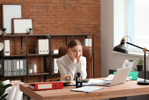 Уставшая женщина-бухгалтер работает за столом в офисе - Фото, изображение