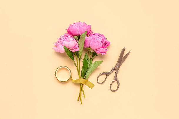 Beautiful peony flowers, scissors and adhesive tape on color background - Photo, Image