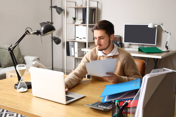 Молодой человек работает в срок в офисе - Фото, изображение
