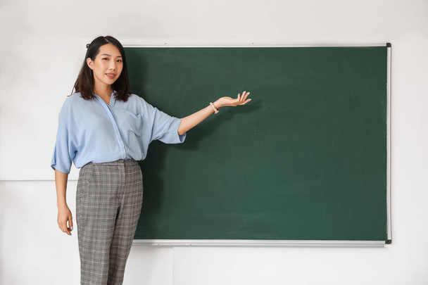Professora asiática perto de quadro-negro em sala de aula - Foto, Imagem