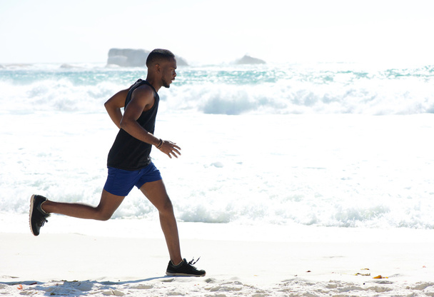Jeune homme en bonne santé faire du jogging à la plage
 - Photo, image