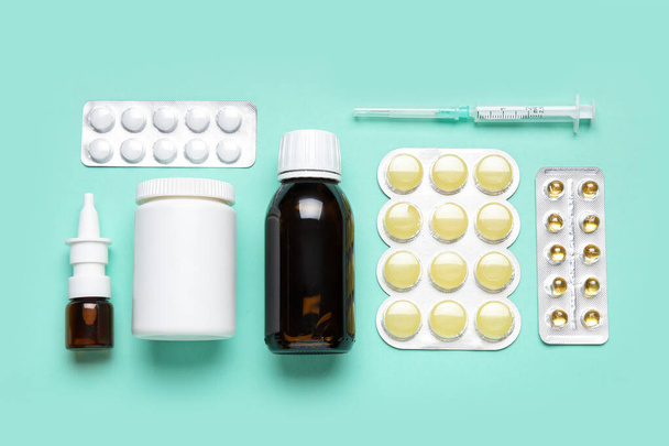 Διαφορετικά χάπια, σύριγγα και μπουκάλια φαρμάκων σε μπλε φόντο - Φωτογραφία, εικόνα