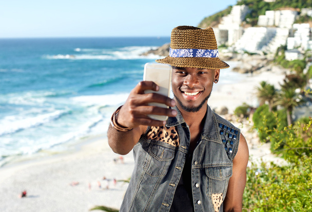 Hombre guapo tomando selfie mientras está de vacaciones en la playa
 - Foto, imagen