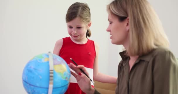 Curiosa bambina e madre conoscere molti luoghi del mondo con globo a casa. Geografia educazione e pianificazione dei viaggi - Filmati, video